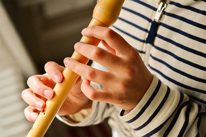 Nahaufnahme von Kind beim Flöte spielen